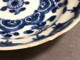 a blue and white plate with a flower design on it