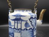 blue and white teapot with a handle on a table