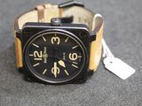 a black and tan watch with a tag on it