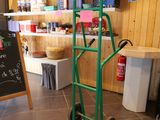 a green hand truck with a chalk board on the back of it