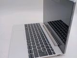 a silver laptop with a black keyboard on a white surface