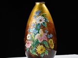 a brown vase with flowers painted on it on a table