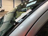 a sticker on the windshield of a car that is parked in a parking lot