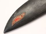 a close up of a knife on a white surface