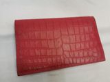 a red leather wallet with crocodile skin on it