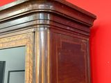 une grande armoire en bois avec un miroir accroché au mur