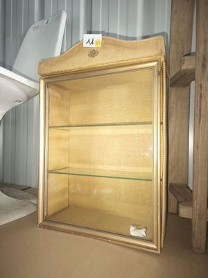 a toilet sitting next to a wooden cabinet in a room