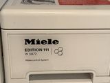 the front of a white washing machine sitting on top of a counter