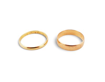 two gold wedding rings on a white background