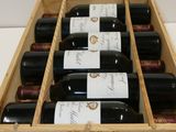 six bottles of wine in a wooden box on a table