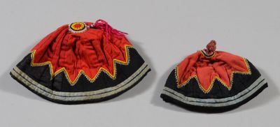 une paire de petits chapeaux rouges et noirs ornés d'un motif rouge et jaune