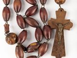 rosary with wooden beads and a wooden crucift on a white background