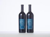 two bottles of wine sitting on top of a white table