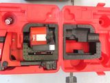 deux outils rouges dans un étui rouge posé sur une surface blanche