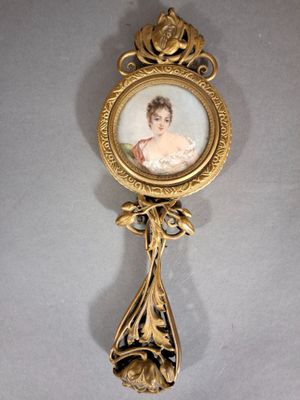 une cuillère ancienne en or sur laquelle est représentée une femme avec un enfant