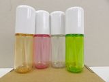four different colored bottles of perfume sitting on top of a cardboard box