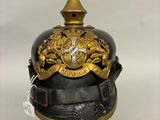 un vieux casque noir et doré orné d'une couronne dorée