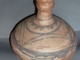 a brown vase with a design on it sitting on a table