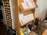 a wooden shelf with a sign on it in the corner of a room