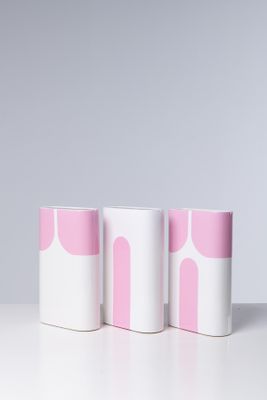 trois tasses roses et blanches posées sur une table blanche