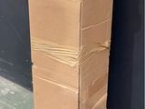 a large cardboard box sitting on the ground next to a black wall