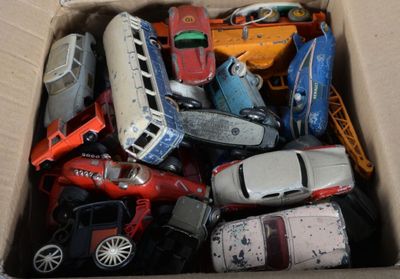 de nombreuses petites voitures dans une boîte en carton posée sur le sol