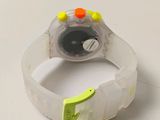 a wrist watch with a plastic band and yellow and orange buttons