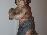a small statue of a child hanging from a string