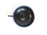 a small black bowl with a handle on a white surface