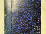 un vieux livre à la couverture bleue posé sur une table