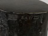 a close up of a black vase on a white surface