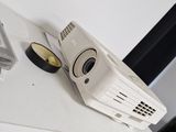 a small projector sitting on top of a white shelf