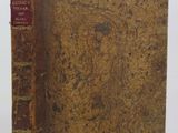 an old book sitting on top of a table next to a white wall