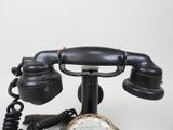 an old fashioned telephone with a clock on top of it