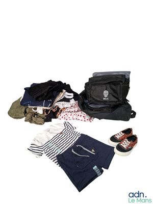 un sac de vêtements et une paire de chaussures posés par terre