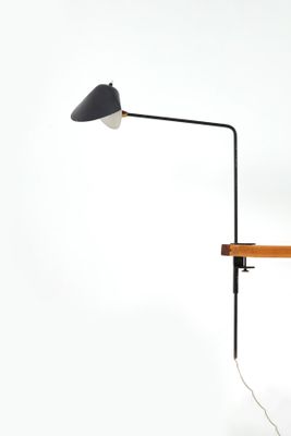 black and white lamp on a wooden table against a white wall