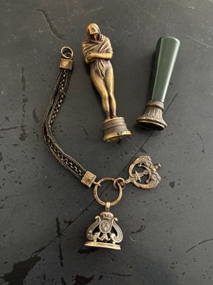 un collier avec une breloque et une bouteille posés sur une table