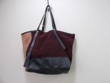 un sac fourre-tout marron et noir accroché à un mur