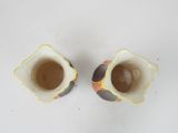 two small vases that are sitting on a table