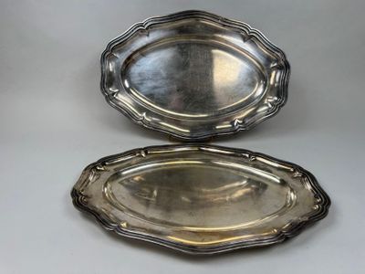 two silver trays on a table with a white background
