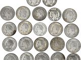 a pile of old silver coins on a white background