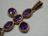un gros plan d'une croix ornée de pierres violettes
