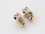 a pair of gold and silver earrings on a white surface