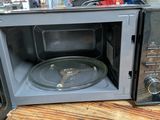 a microwave with a pan inside of it sitting on a table