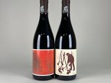 two bottles of wine sitting next to each other on a table