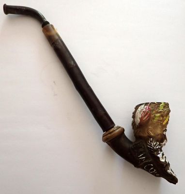 une pipe sur laquelle repose une feuille, posée sur une table