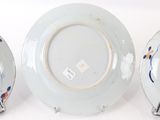 three plates with designs on them sitting on a white surface
