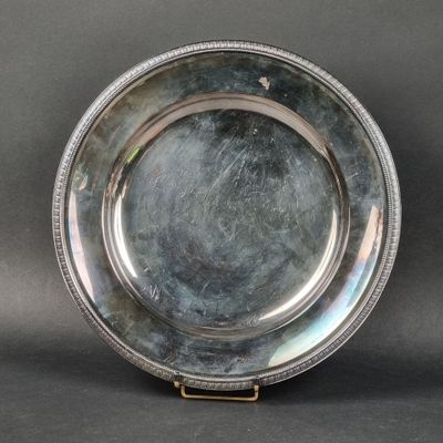 une assiette ancienne en argent, ornée d'un liseré en relief sur le bord