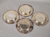 four silver plated dishes are sitting on top of a table