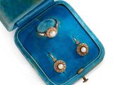 une paire de boucles d'oreilles en perles et diamants, présentée dans un écrin en velours sur fond blanc